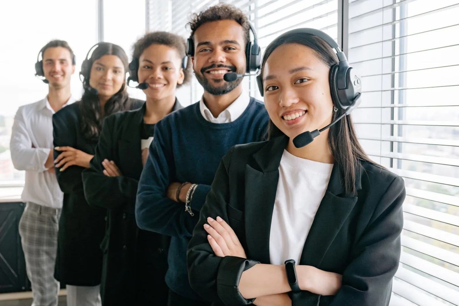 Professional help desk team wearing headsets, photo via Pexels